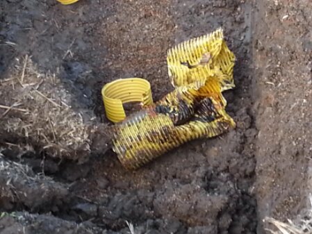 Kontrolle einer landwirtschaftlichen Drainageleitung auf einem Feld